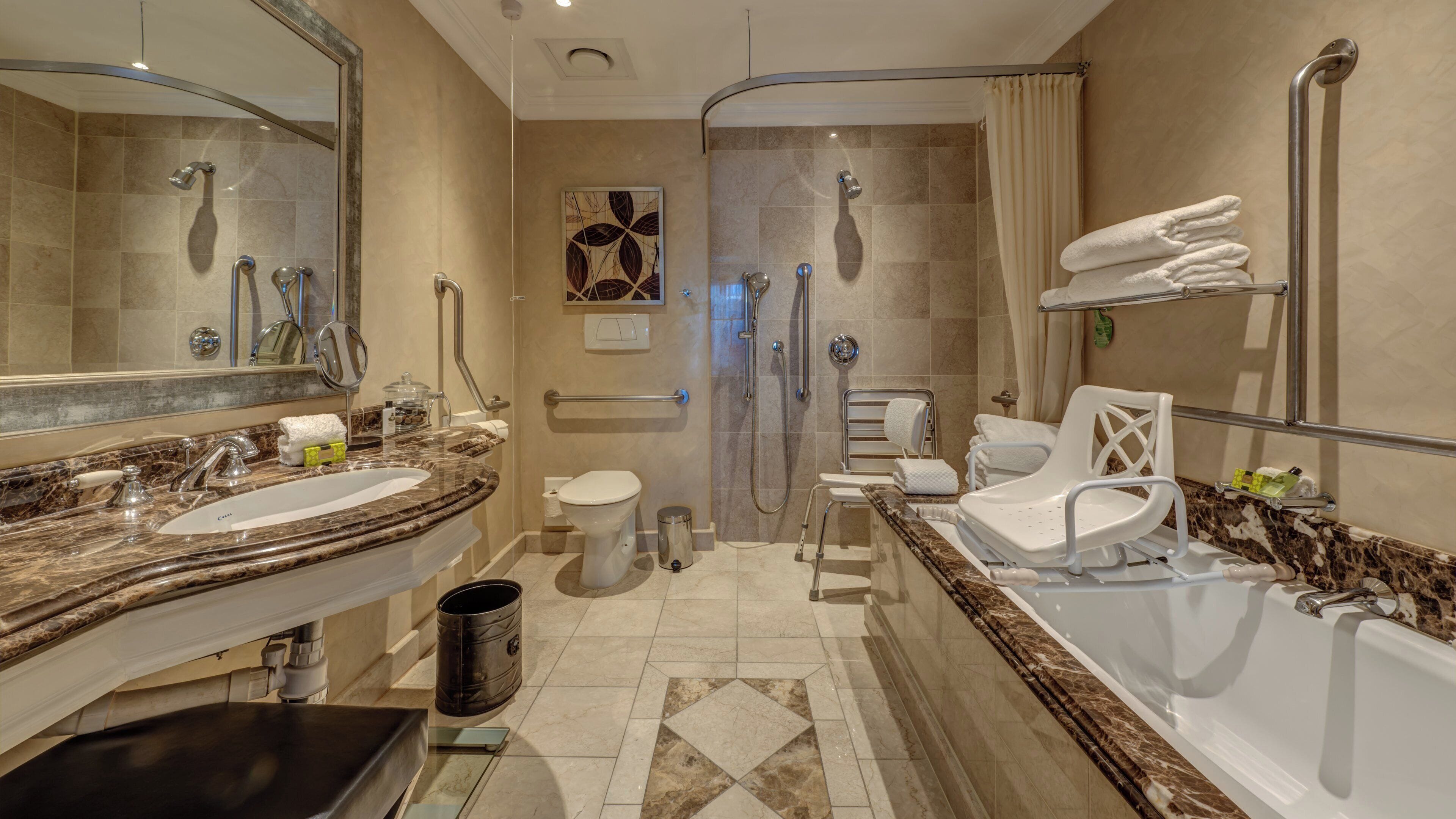 Un baño moderno con bañera, ducha, inodoro y tocador con lavamanos.