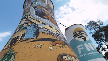 Une structure cylindrique ornée d’une fresque murale, dont une partie du texte est visible, et un ciel dégagé.