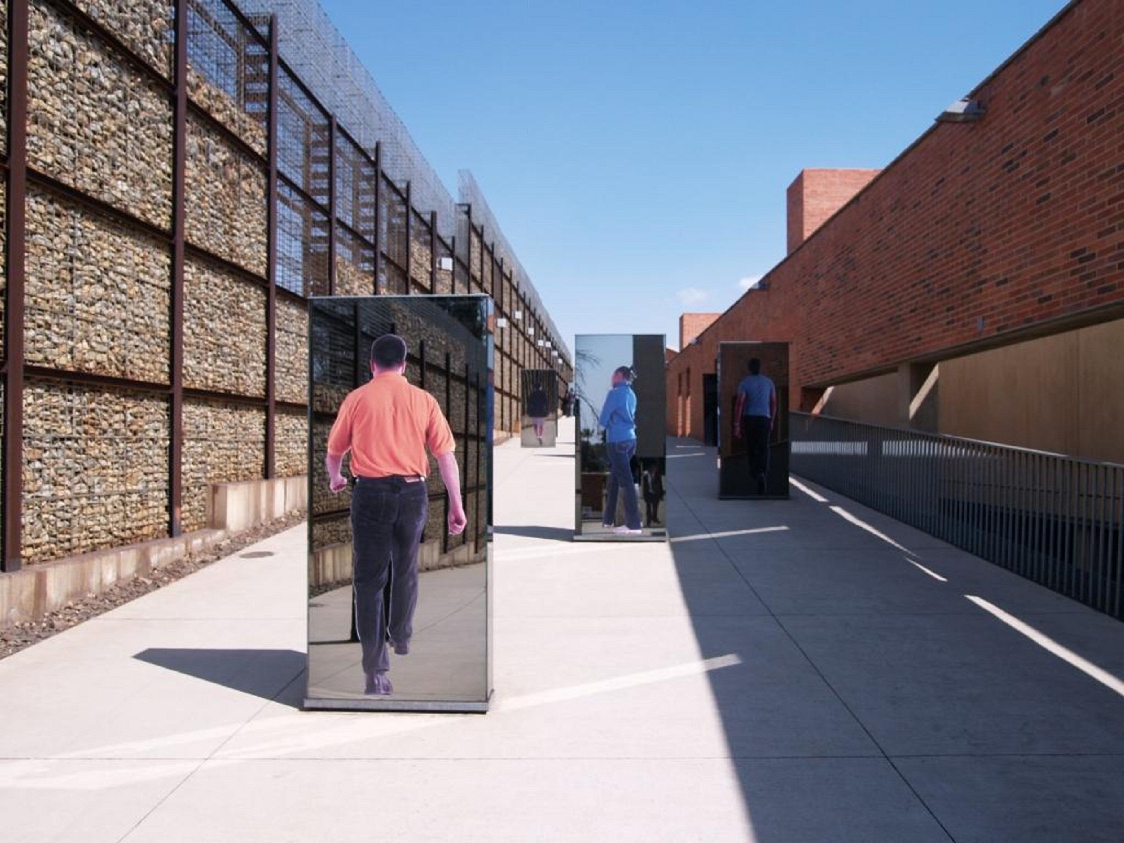 A walkway with a stone wall on one side and a brick wall on the other.