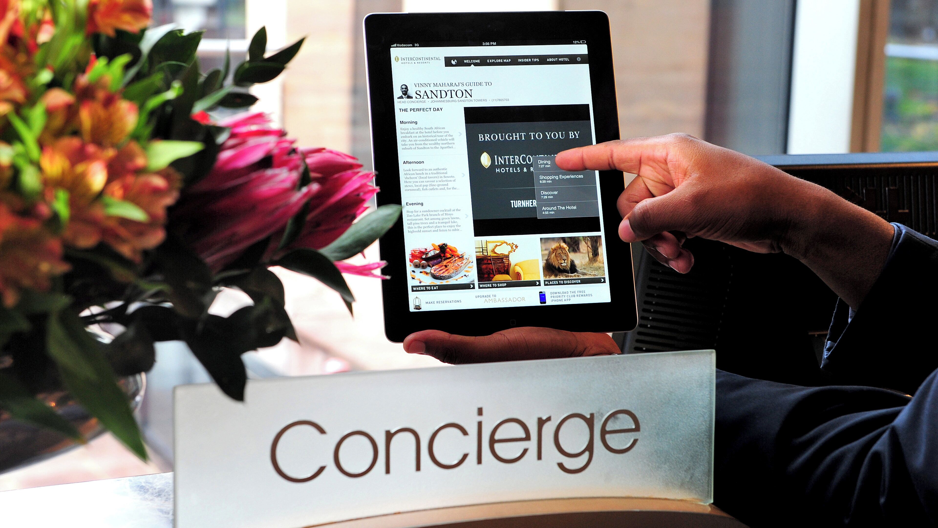 Una tableta mostrando una guía hotelera con secciones para restaurantes, tiendas y lugares para comer.
