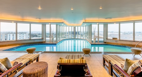 Una piscina techada, sillones reclinables de piscina