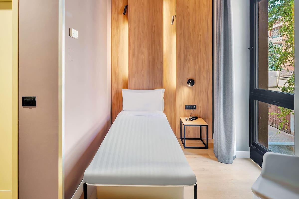 Habitación individual estándar | Edredón, minibar, caja de seguridad en la habitación y escritorio