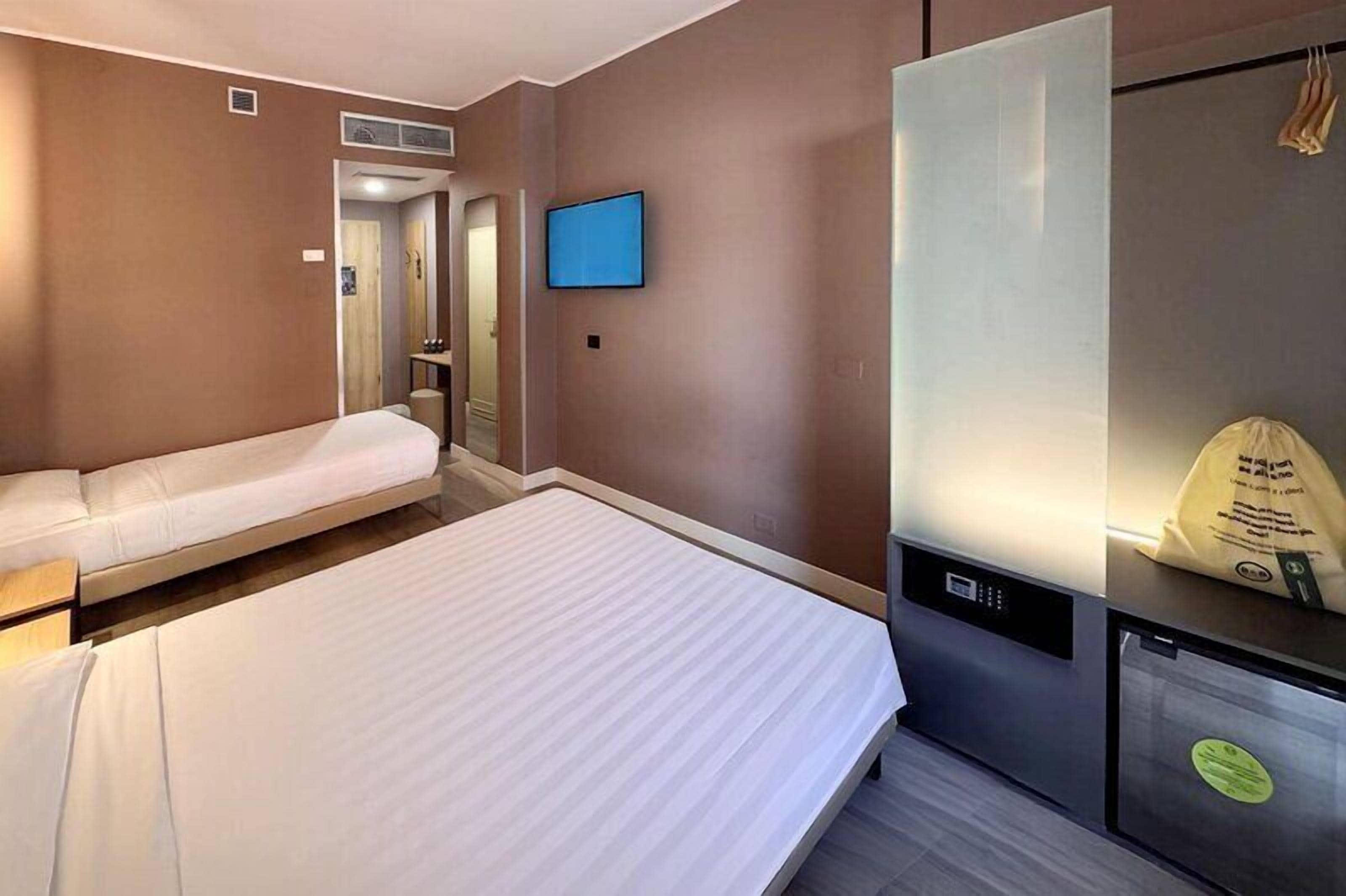 Ein Hotelzimmer mit Bett, einer Couch, einem Fernseher und einer Minibar.