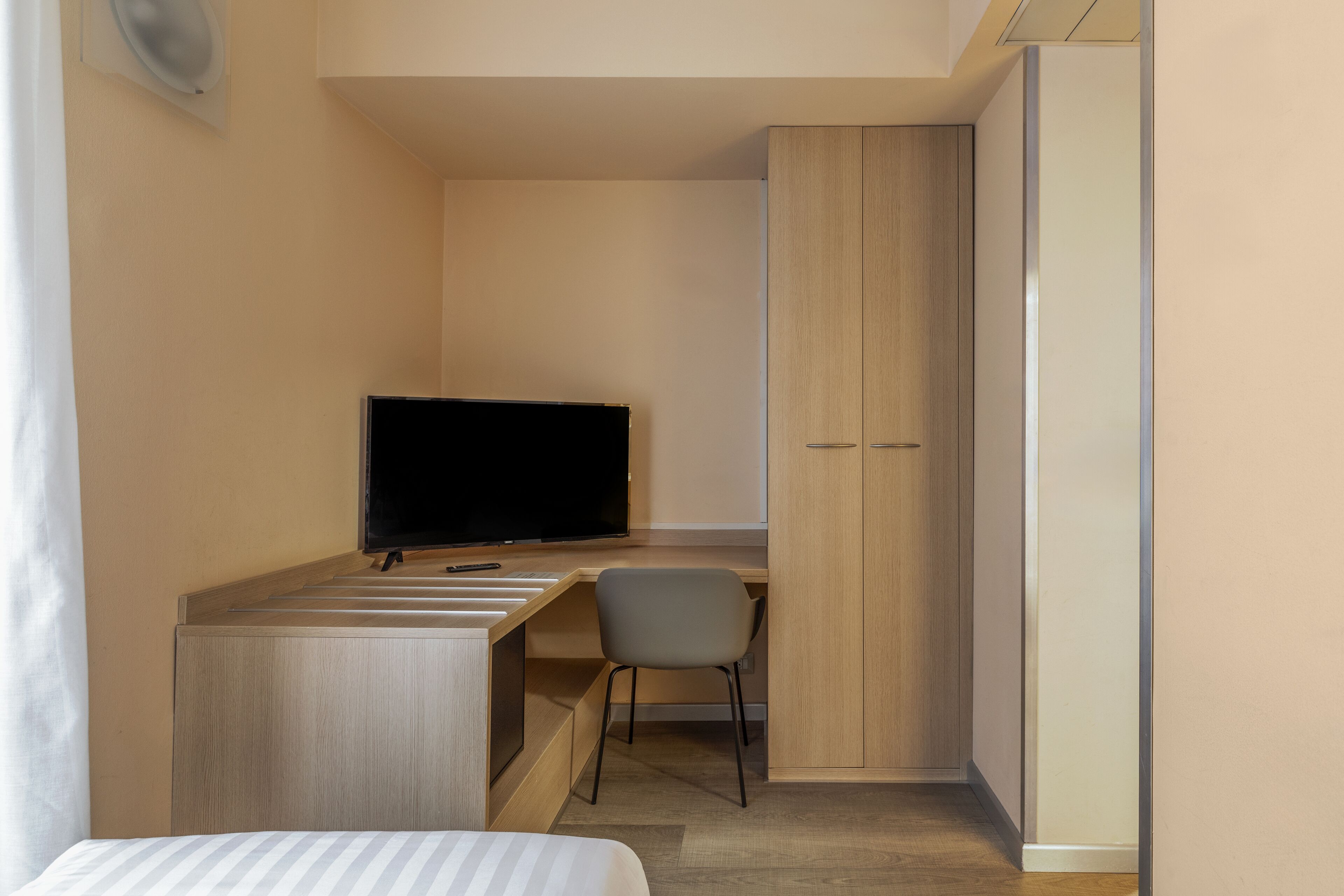 Habitación individual estándar | Edredón, minibar, caja de seguridad en la habitación y escritorio 