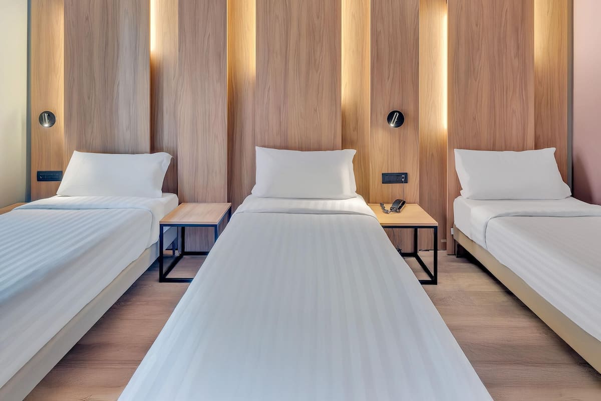 Habitación triple estándar | Edredón, minibar, caja de seguridad en la habitación y escritorio