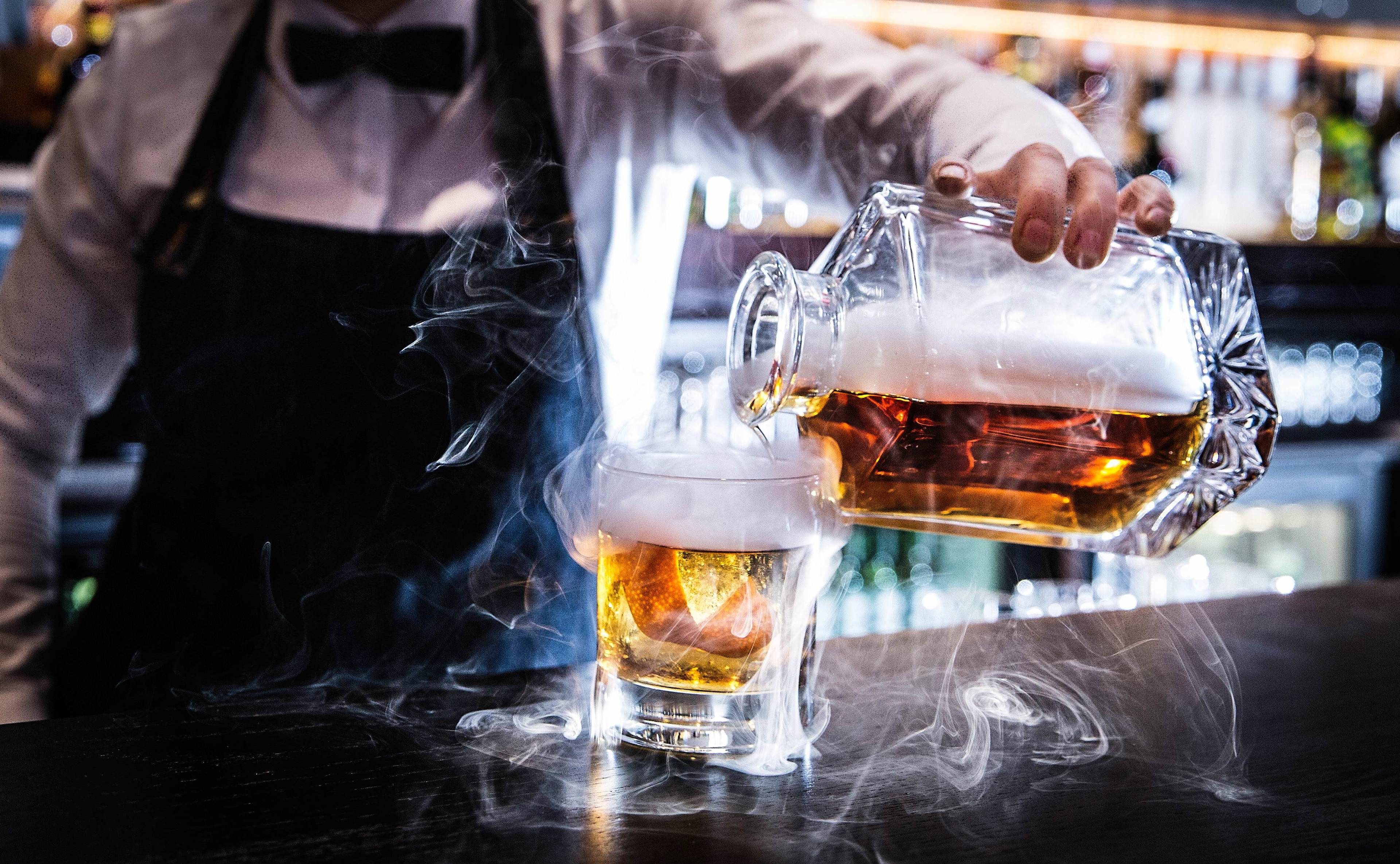 En bartender som häller öl i ett glas.