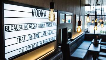Interior de un restaurante con un letrero que dice 'VODKA' y un eslogan.