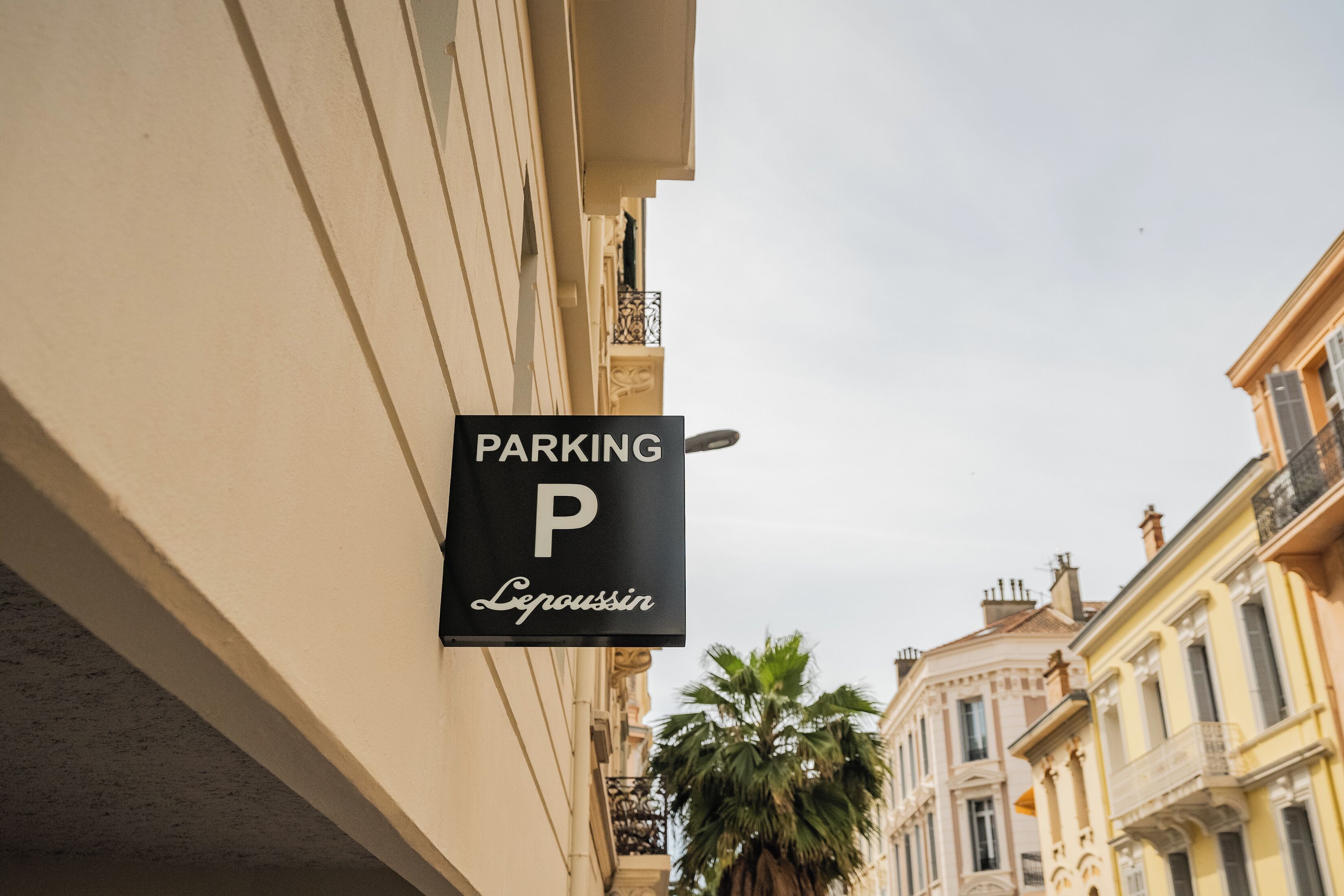 Een gebouw met een 'PARKING'-bord, wat aangeeft dat er een parkeerplaats in de buurt is.