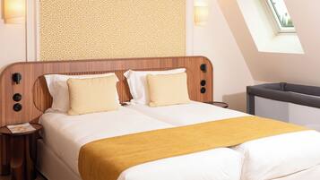 Ein Hotelzimmer mit einem großen Bett, einem hölzernen Kopfteil, zwei Nachttischen, einem kleinen Tischchen, einer Wand mit Muster und einem Oberlicht sowie Blick ins Freie.