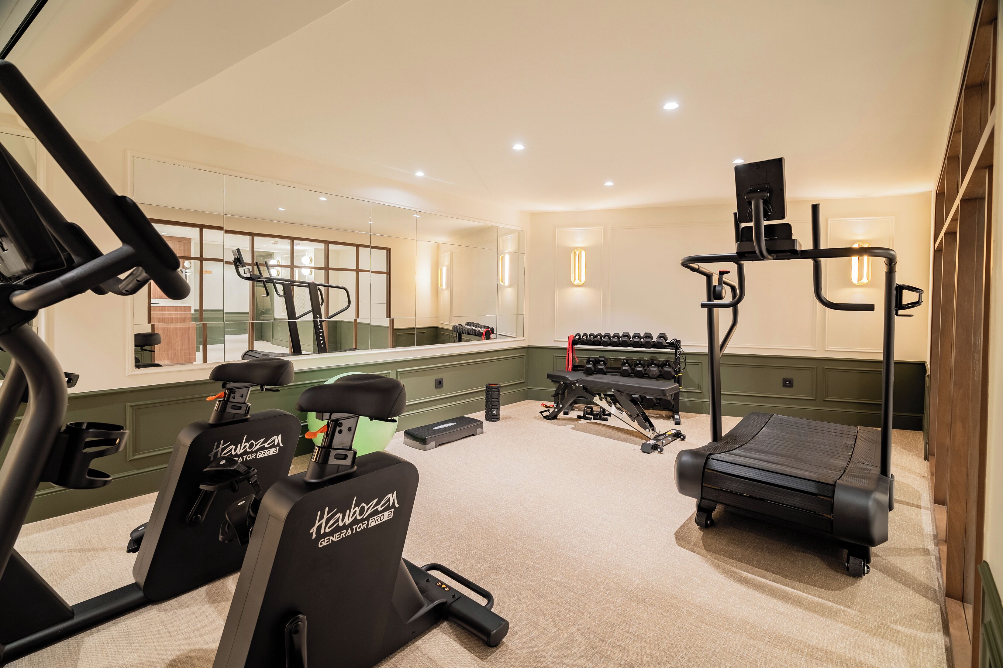 A gym with stationary bikes, a treadmill, and weight machines.