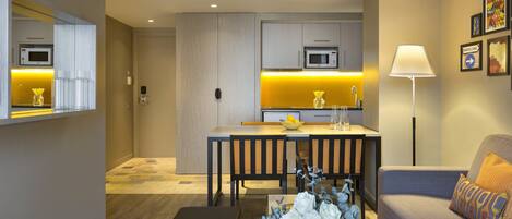 Una habitación de hotel moderna con comedor, sofá y lámpara.