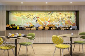 A breakfast bar with a map, seating, and breakfast items. - Citadines Ramblas Barcelona (Barcelona)