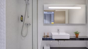 Une salle de bain moderne avec une douche, un lavabo et un miroir.