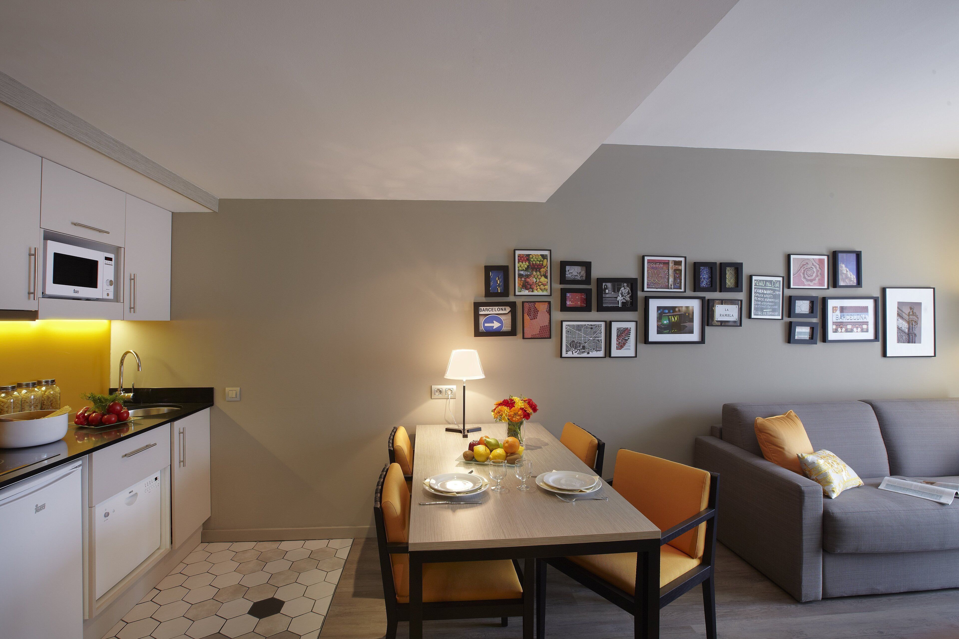 Un espacio habitable compacto con comedor, kitchenette y sofá.