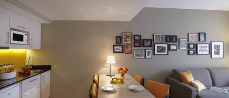 A compact living space with a dining area, kitchenette, and a sofa.