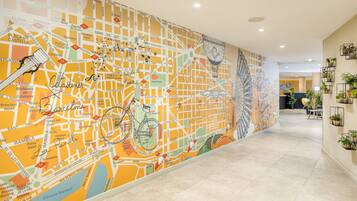Un pasillo con un gran mural colorido en la pared, que muestra una bicicleta y una fuente.