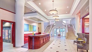 A spacious lobby with a central reception desk, a staircase, and a seating area. - Residence Inn Milwaukee Downtown by Marriott (Milwaukee)