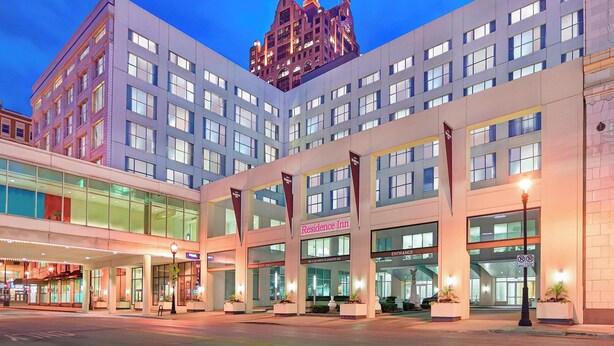 A modern hotel with a prominent entrance, a flag, and a sign indicating the name 'Residence Inn'. - Residence Inn Milwaukee Downtown by Marriott (Milwaukee)