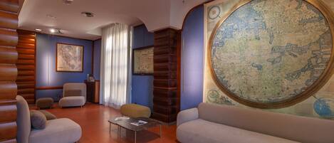 Una sala de estar moderna con un mural de un mapa, asientos cómodos y una pared de acento de madera.
