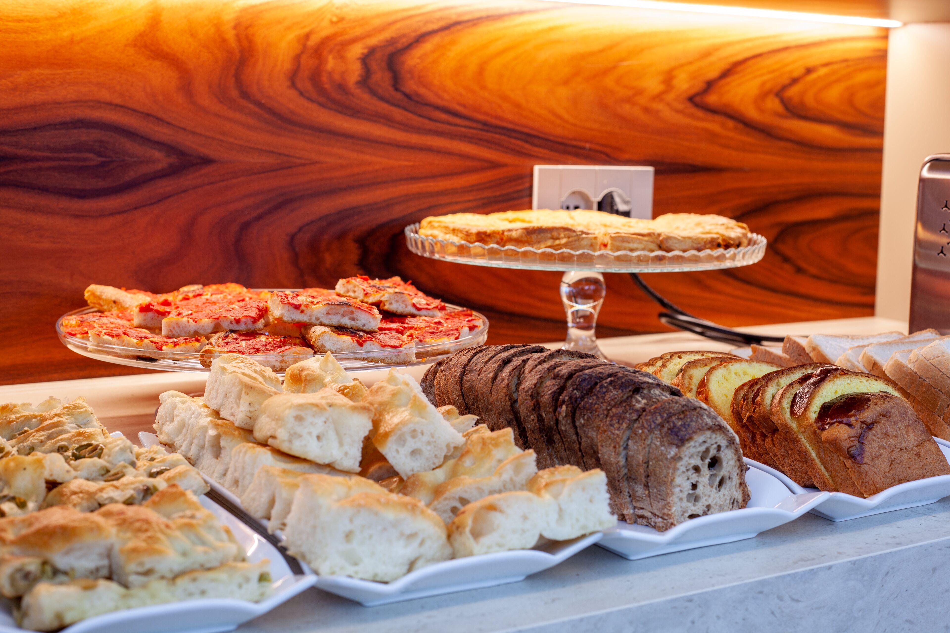 A bakery display with various types of bread and pastries.