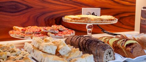 Una vitrina de panadería con diferentes tipos de pan y pasteles.