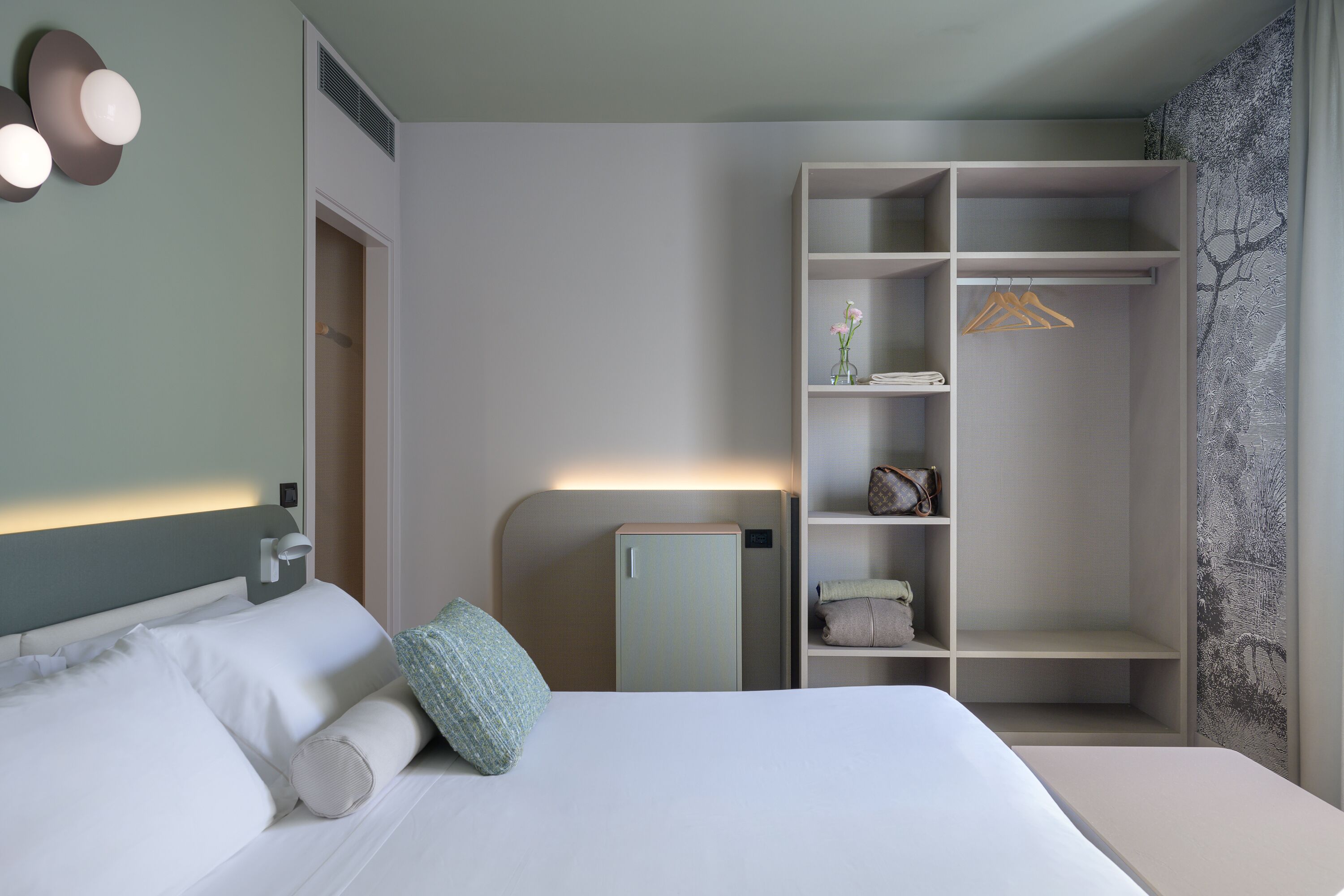 Ein Hotelzimmer mit einem Bett, einem Kleiderschrank und einem Nachttisch.