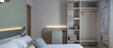 Ein Hotelzimmer mit einem Bett, einem Kleiderschrank und einem Nachttisch.
