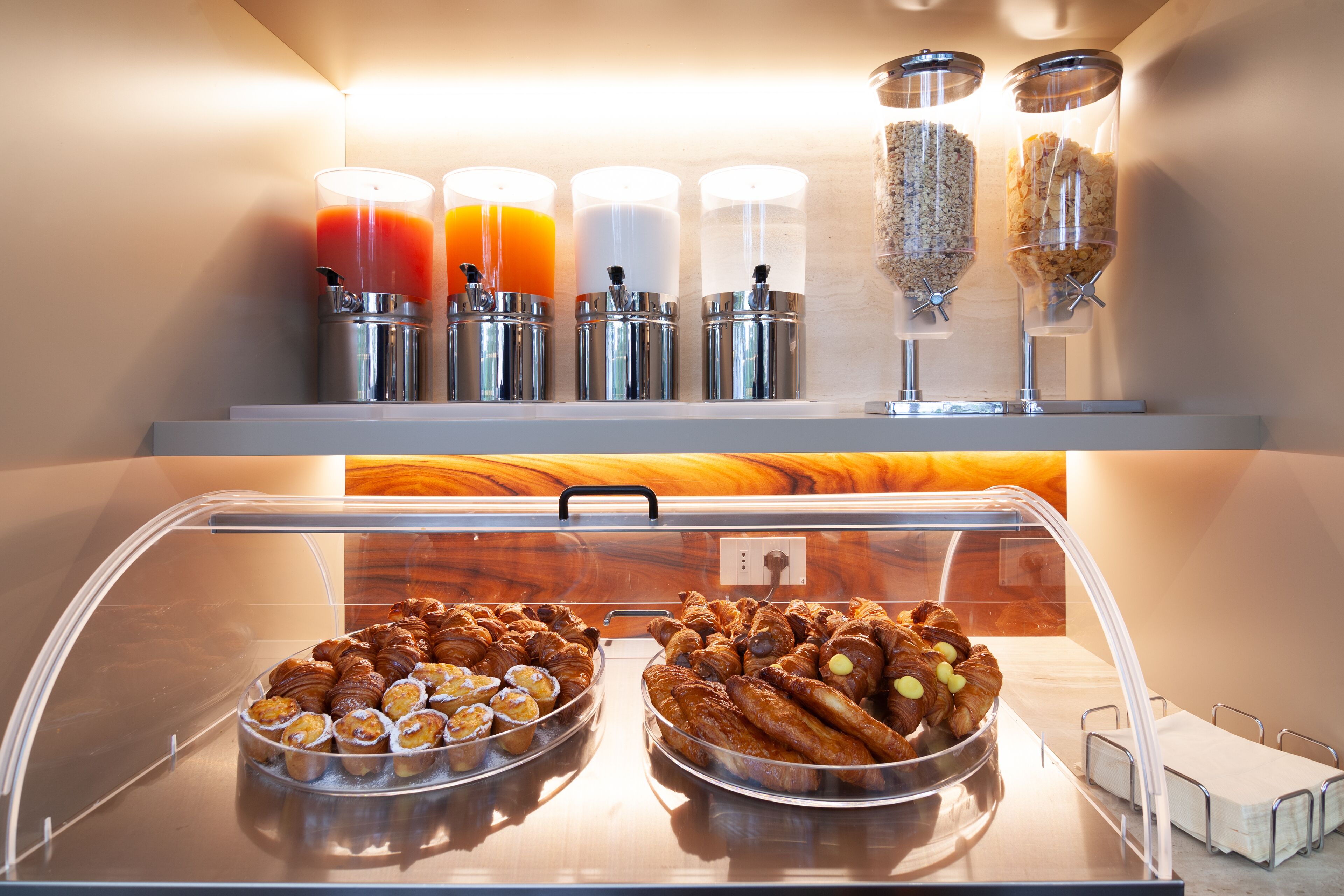 Un bufé de desayuno con pasteles y bebidas.