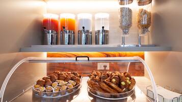 Un buffet de petit-déjeuner avec des viennoiseries et des boissons.
