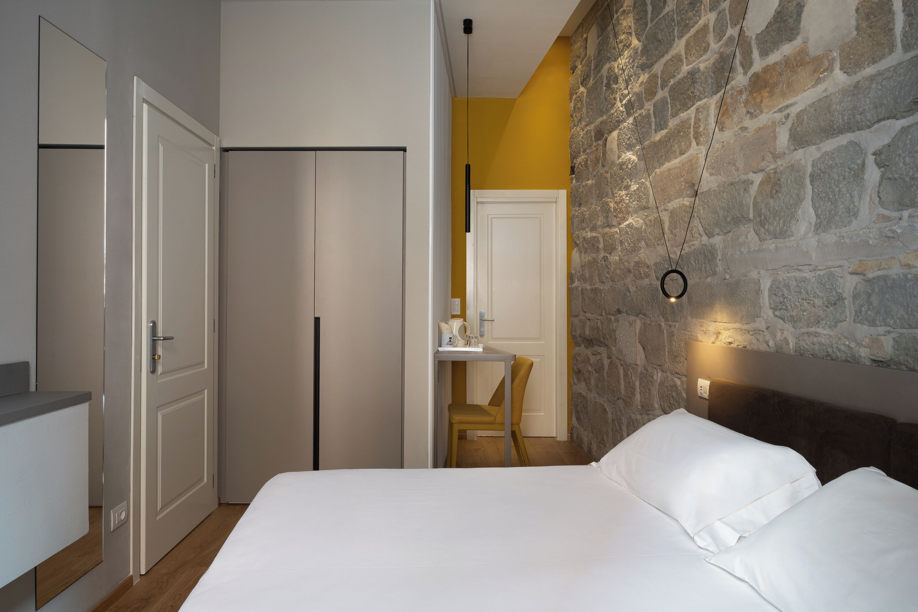 A bedroom with a bed, a desk, and a chair.