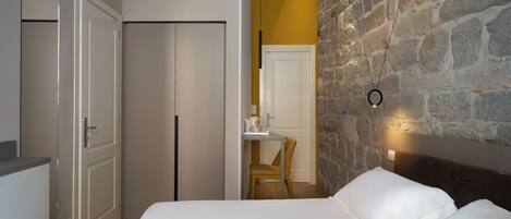 A bedroom with a bed, a desk, and a chair.