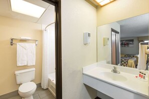 Bathroom features a toilet, shower, sink, and towel rack.