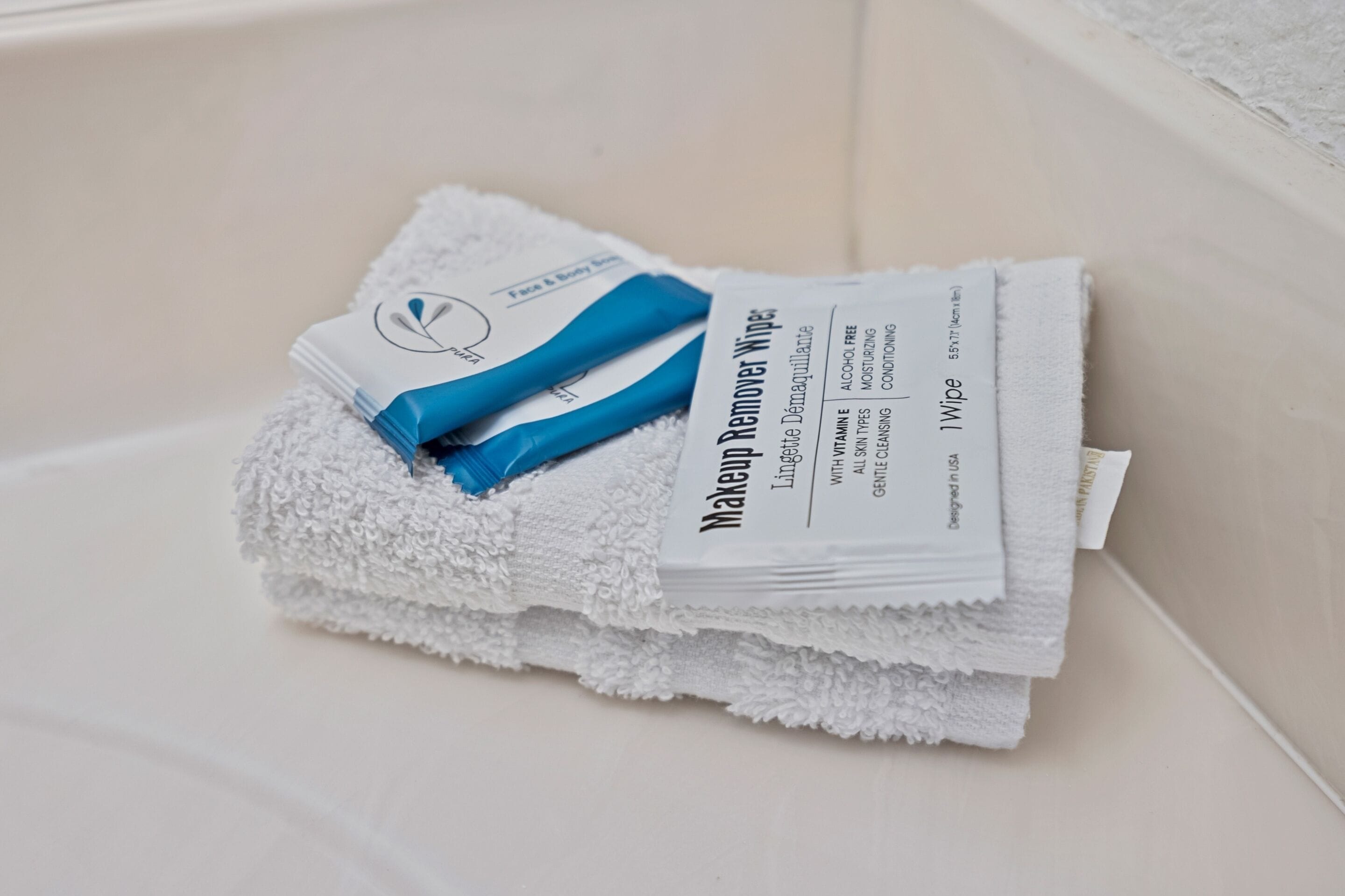 A stack of white towels with a blue handle and a label that reads 'Makeup Remover Wipes.'