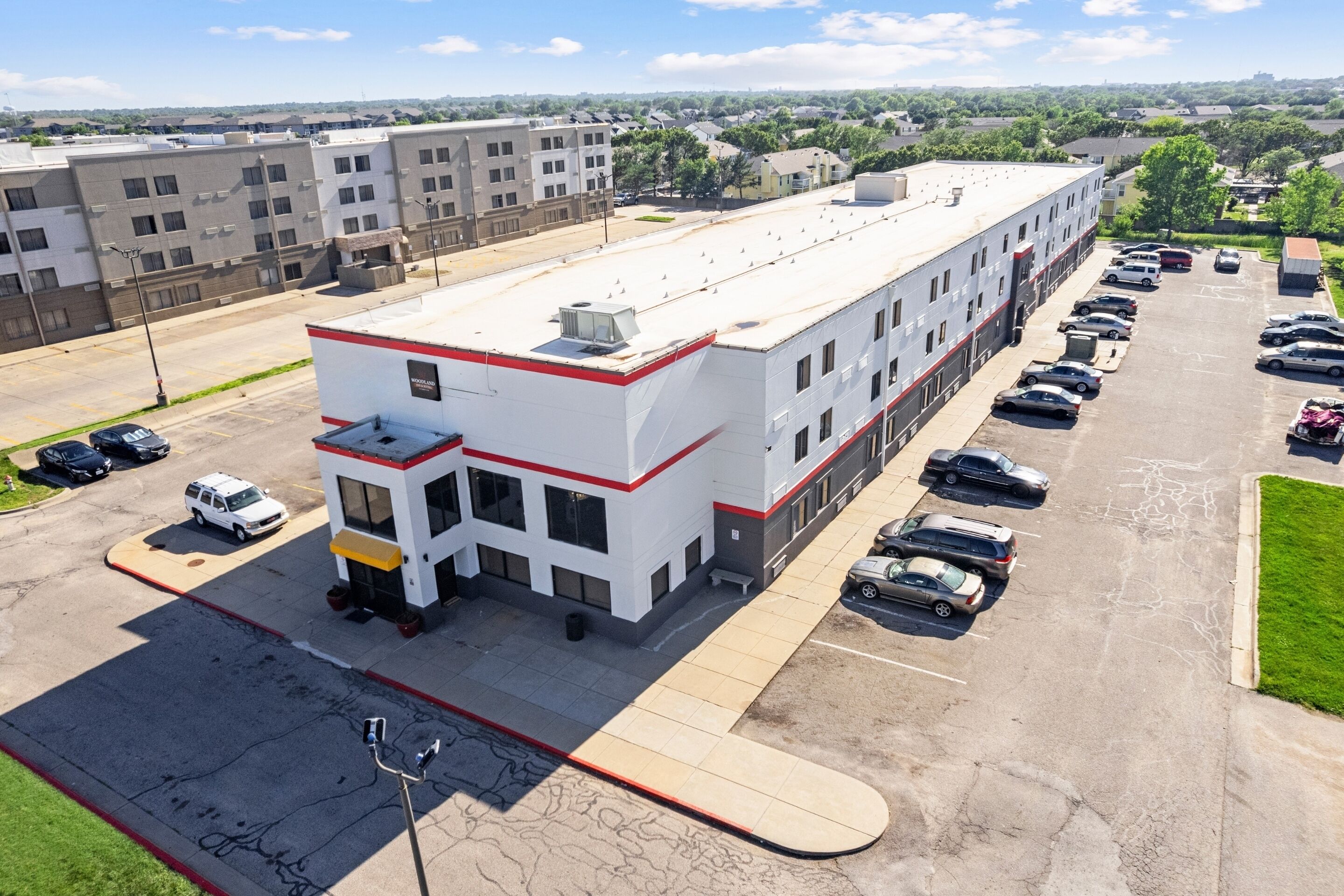 A multi-story parking garage with a flat roof and a row of parked cars.