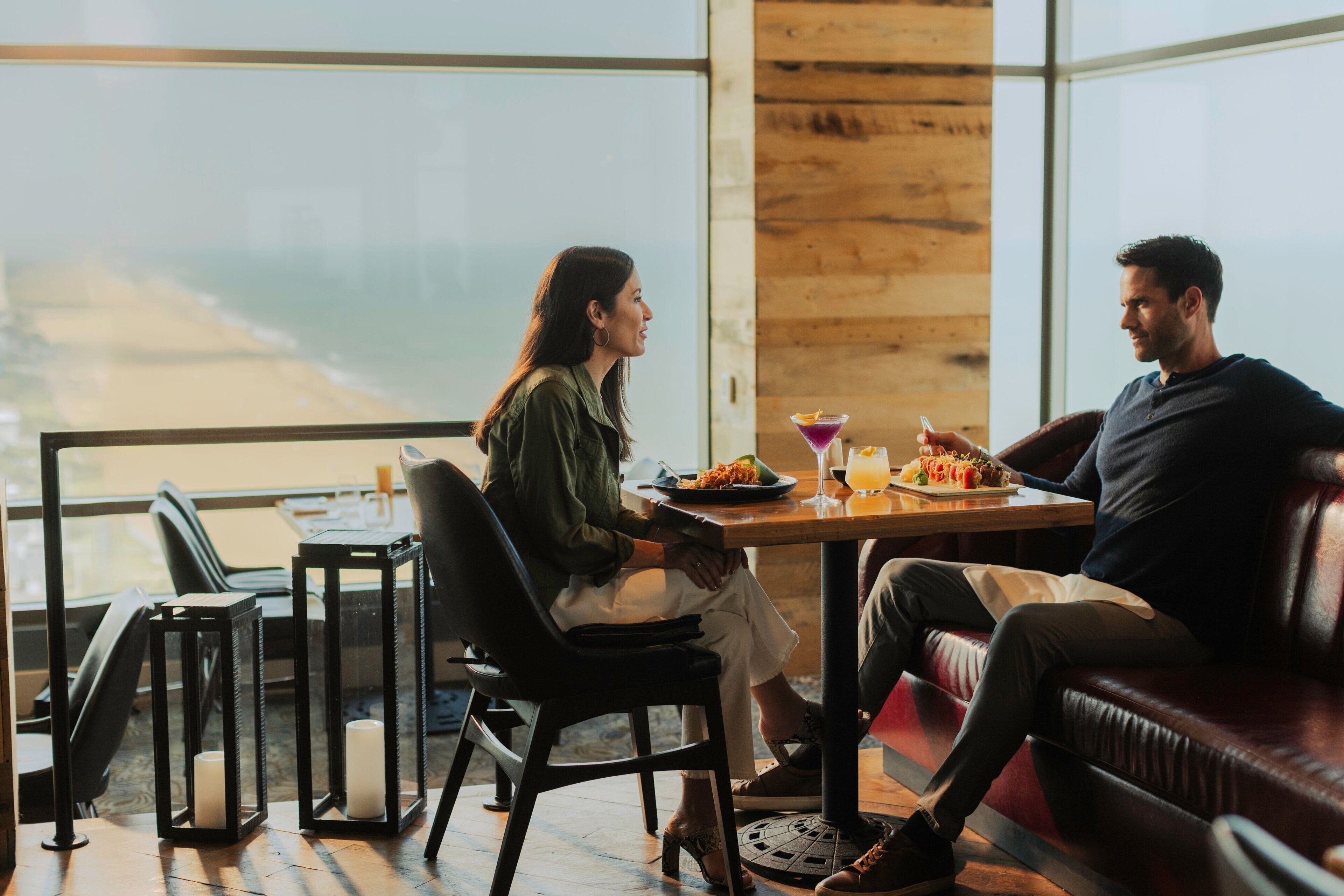 A couple dining at a table with a view of the ocean.
