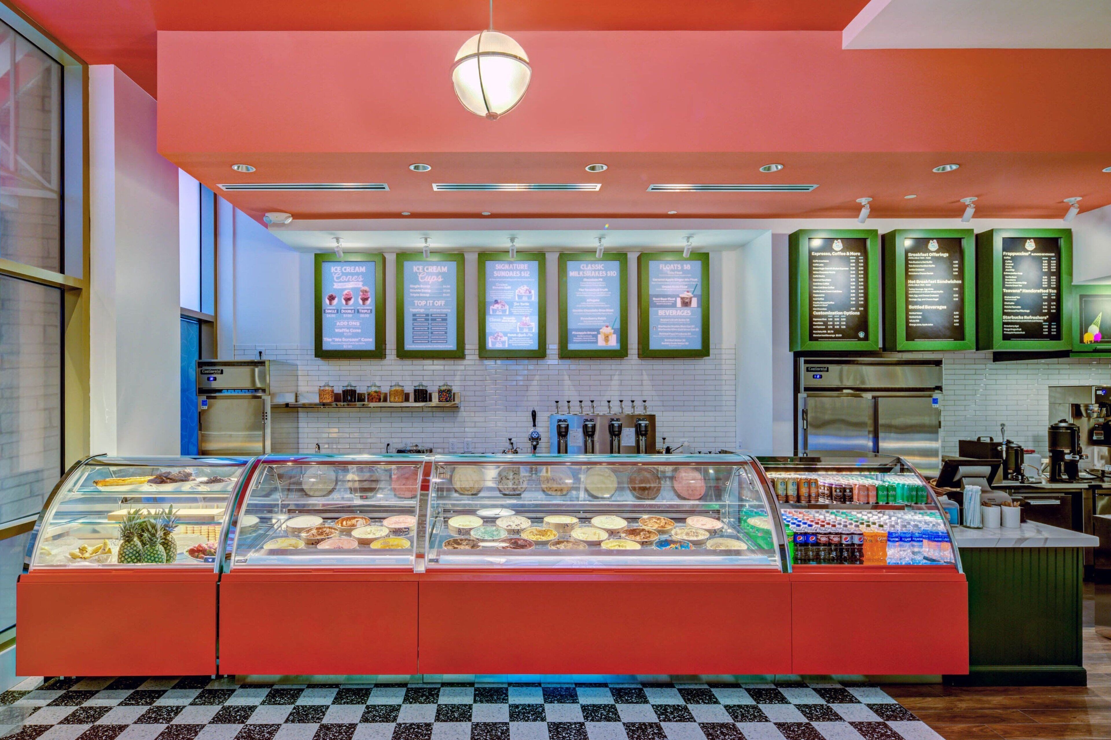 An ice cream parlor with multiple freezers displaying a variety of ice cream flavors and toppings.