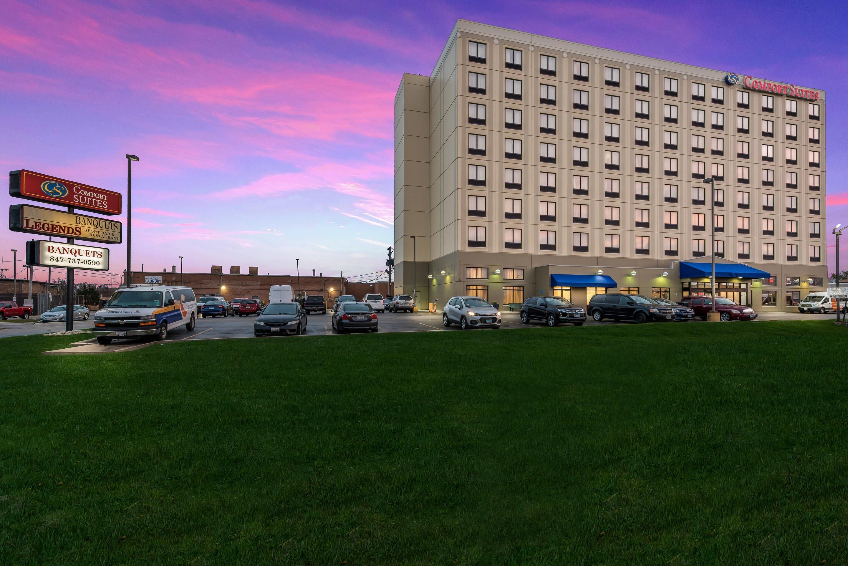 A hotel with a parking lot, a sign for Comfort Suites, and a sign for Legends Sports Bar & Restaurant.