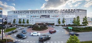 Experience the sleek glass facade of the Fashion Outlets of Chicago, surrounded by beautifully landscaped grounds and convenient parking.