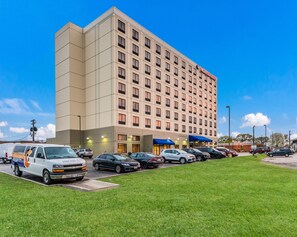 Hotel building with a grid-patterned facade and a parking lot.