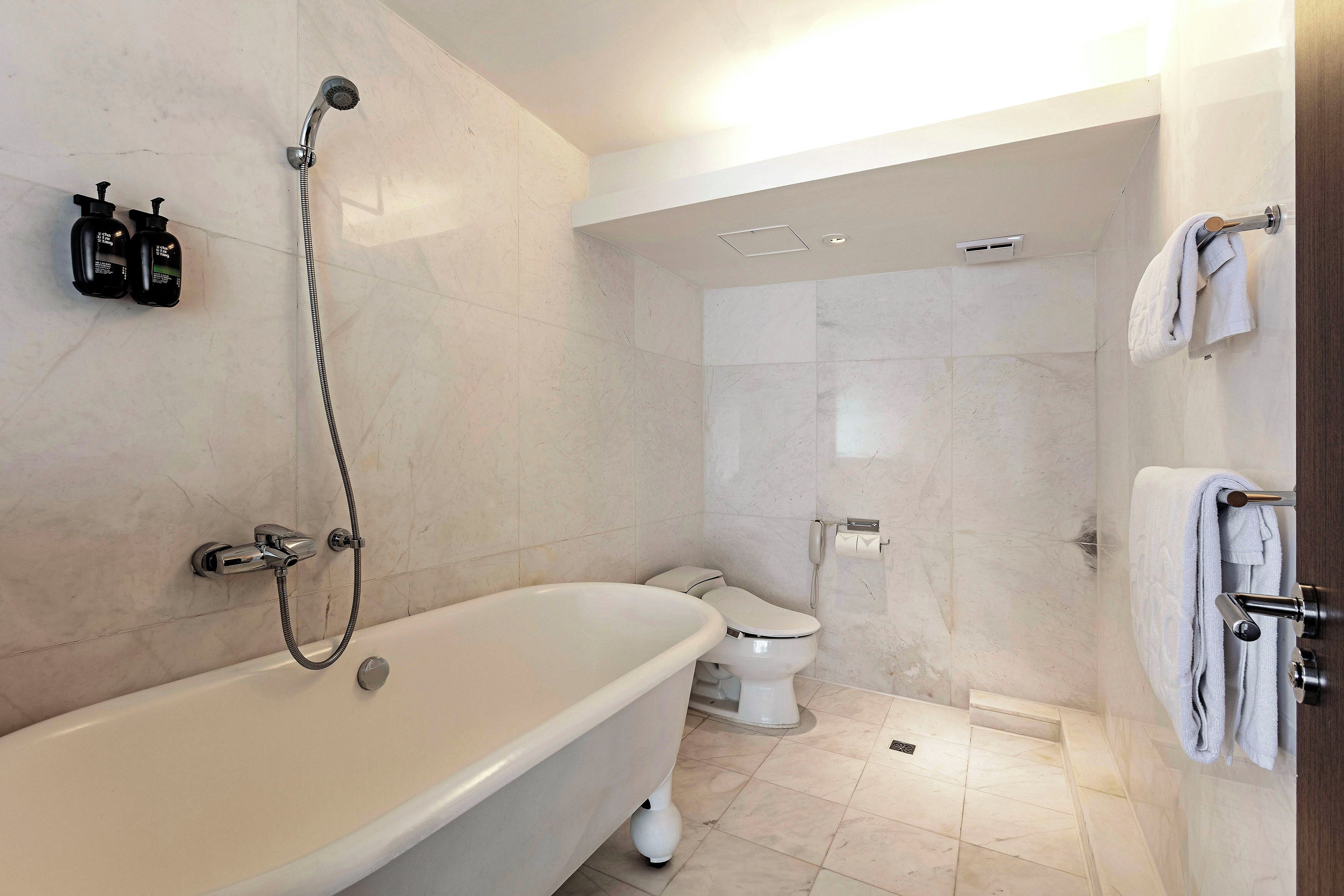 A modern bathroom with a freestanding bathtub, a shower, and a toilet.