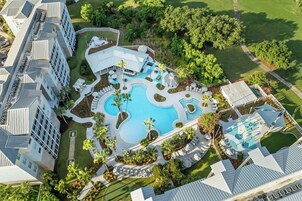 Una piscina al aire libre, sombrillas, sillones reclinables de piscina