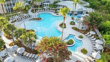 Una piscina al aire libre, sombrillas, sillones reclinables de piscina