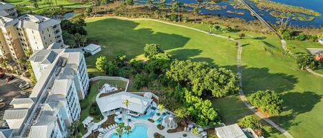 Un resort con una gran piscina, campo de golf y puerto deportivo.