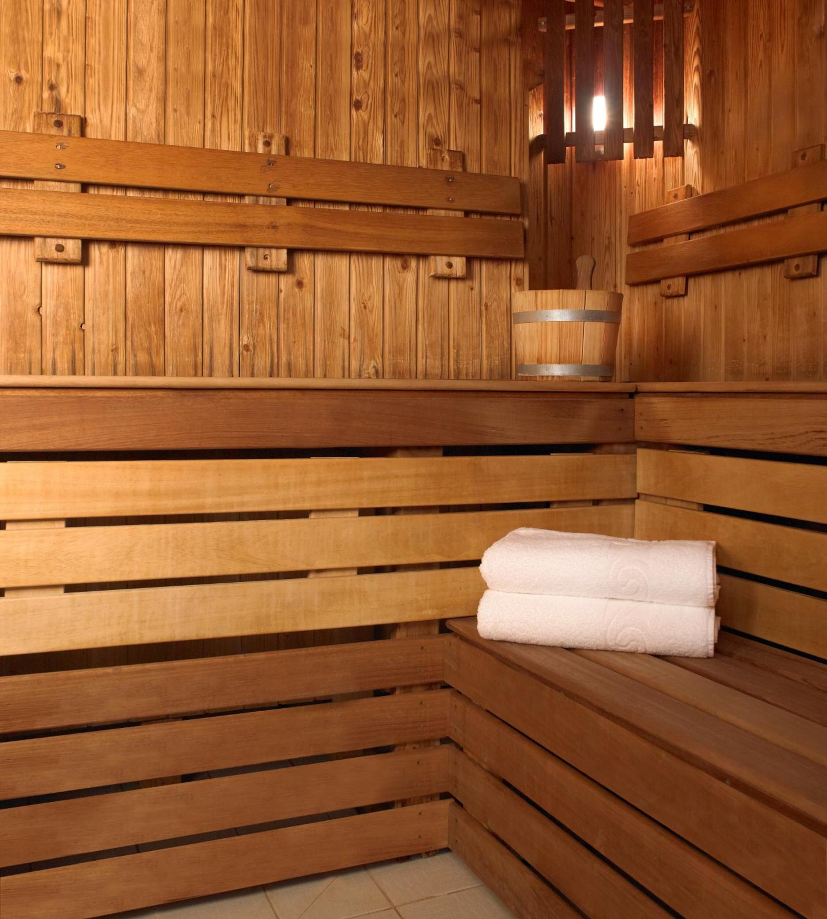 A wooden sauna with benches and a towel.