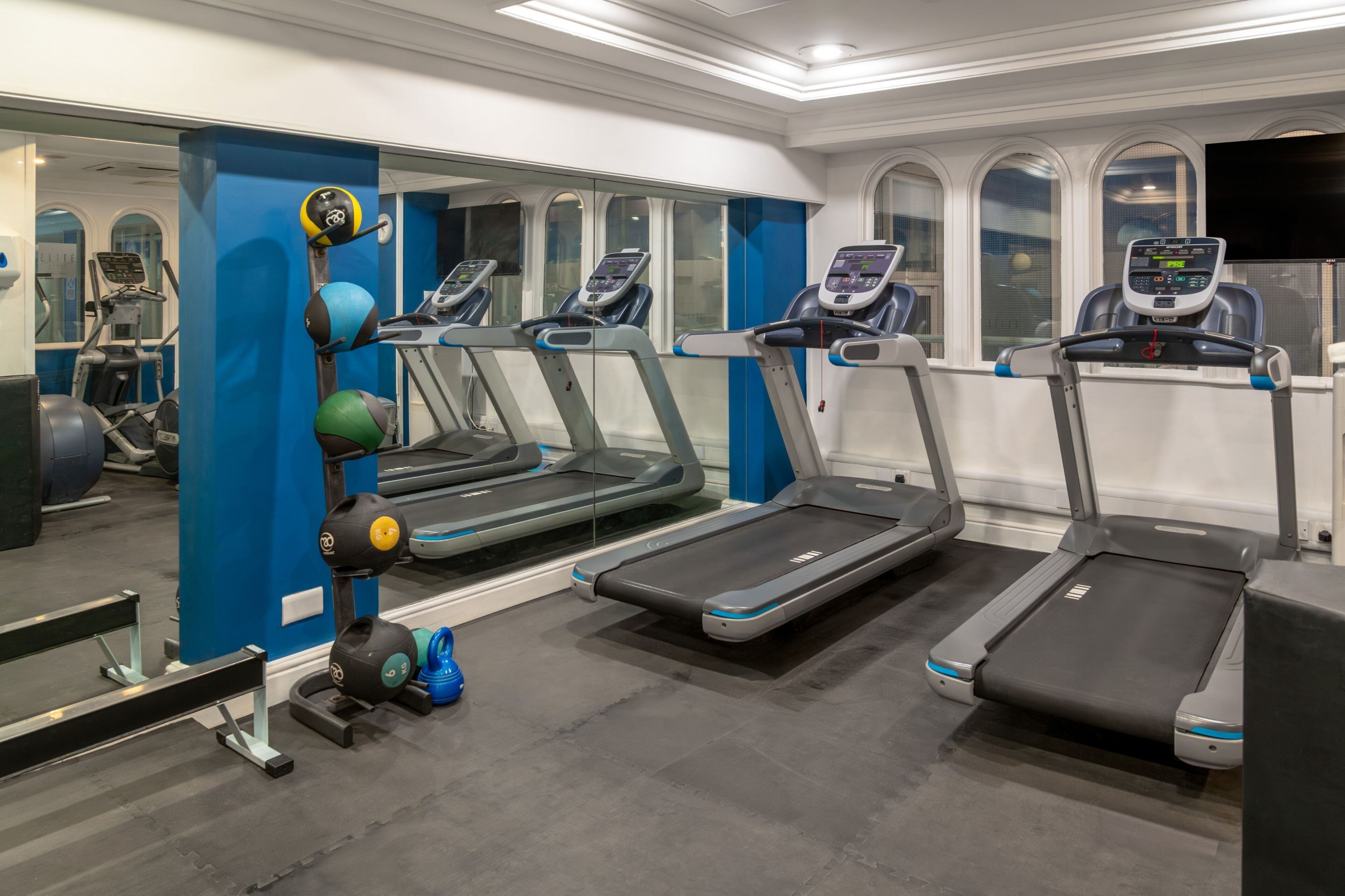 A gym with treadmills, weight machines, and exercise balls.