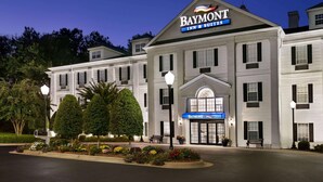Un grand hôtel à deux étages, de style architectural classique, avec une enseigne bien visible indiquant « Baymont Inn & Suites ».