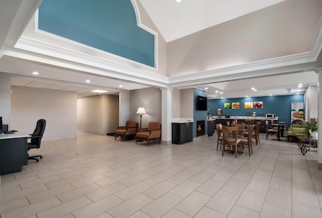 A spacious interior with a high ceiling, a dining area, and a kitchen.