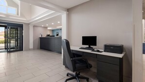 A modern office space with a desk, chair, computer, printer, and a reception area with a counter. - Quality Inn Goldsboro (Goldsboro)