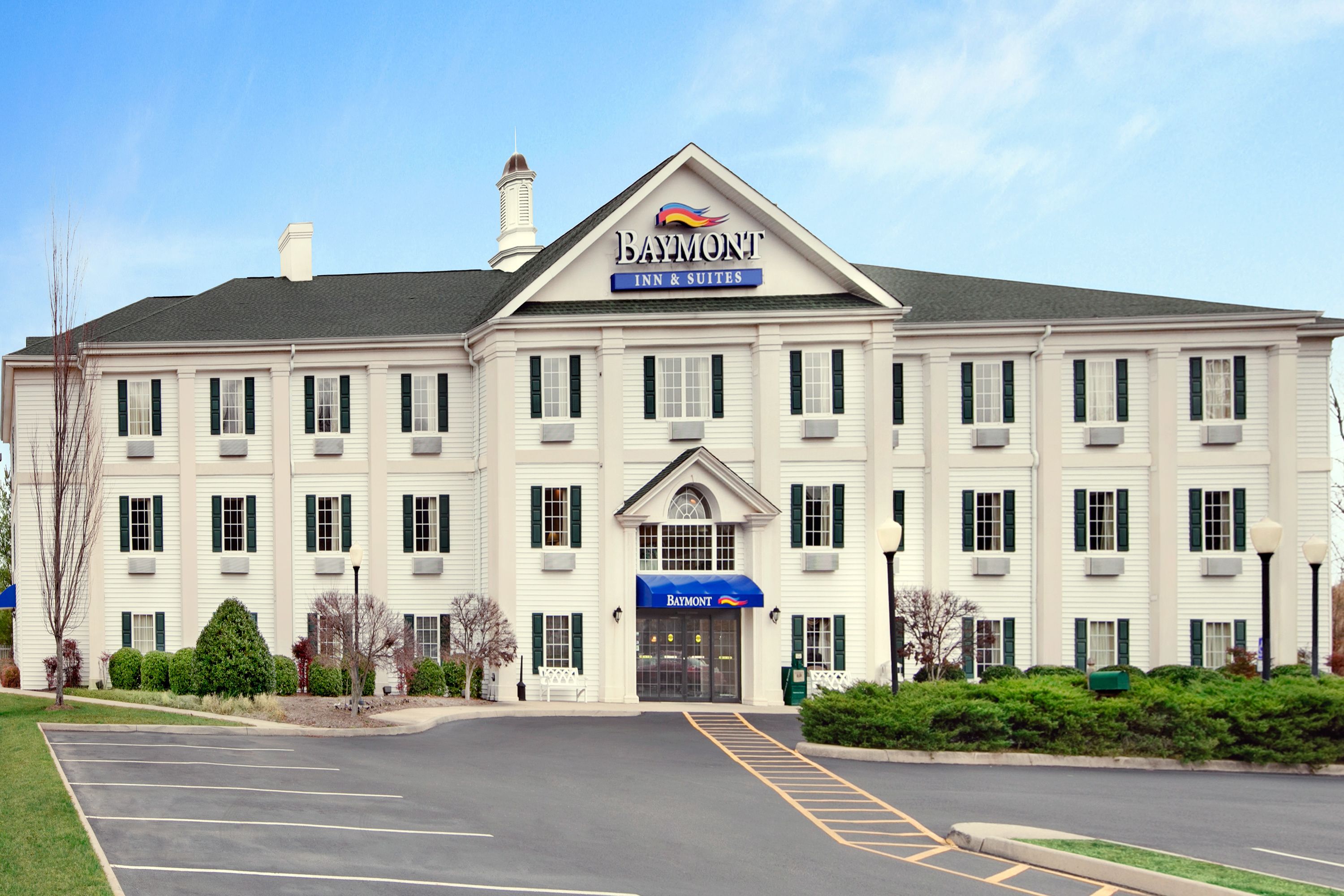 A large, white building with a sign reading "Baymont Inn & Suites".