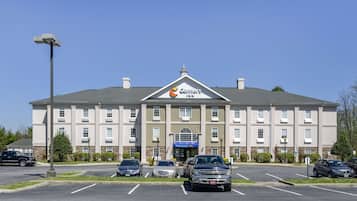 A Comfort Inn hotel with a parking lot and several cars parked in front.
